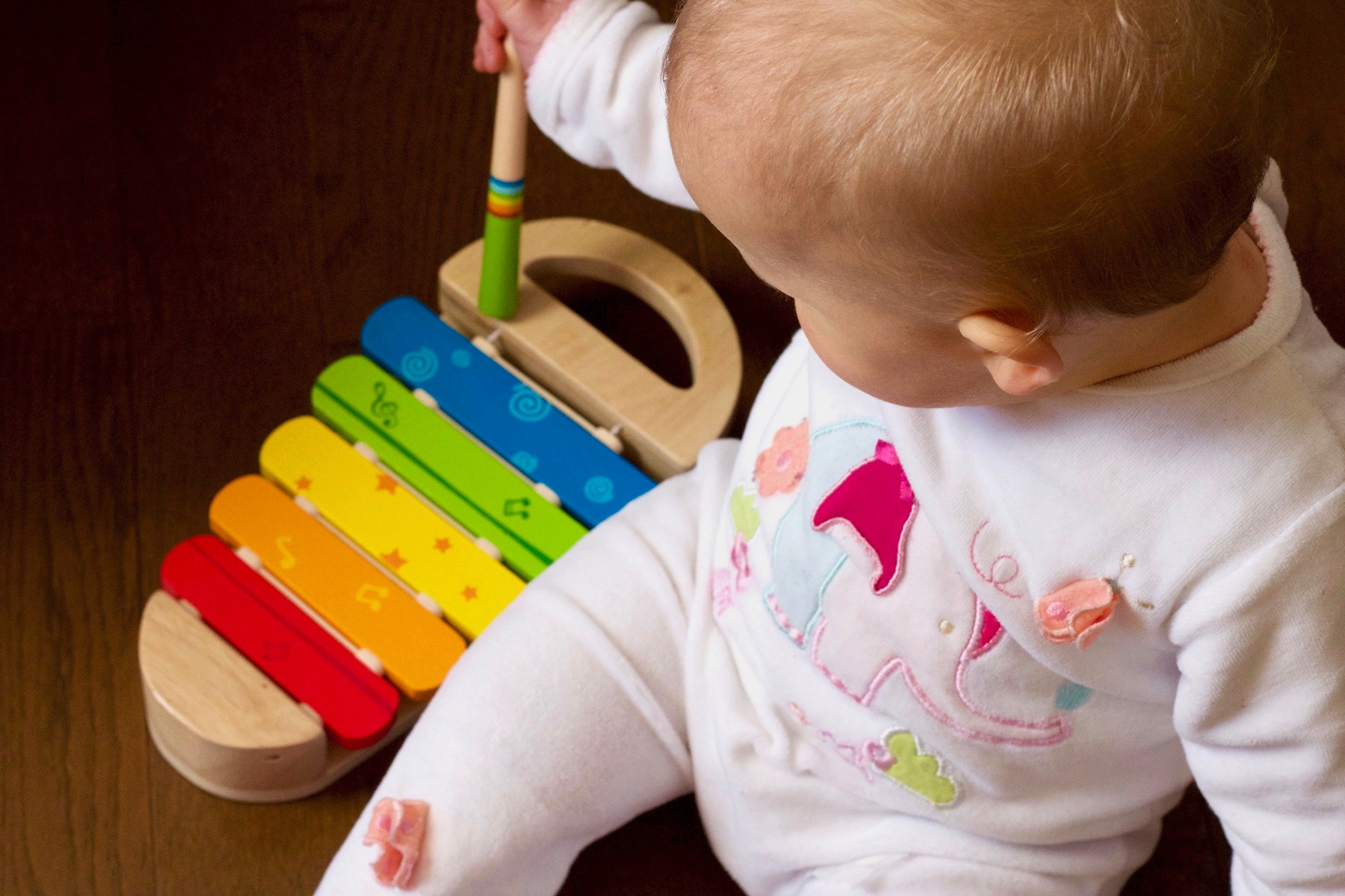 a baby playing with a toy xylophone