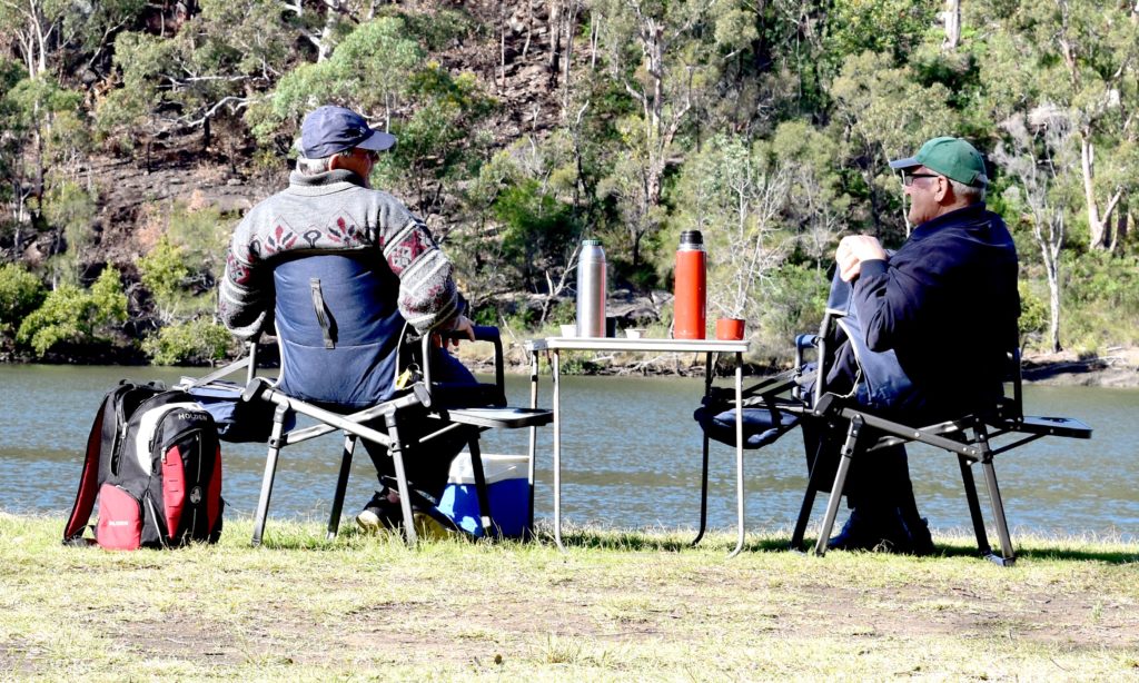 Two men drinking coffee outdoors